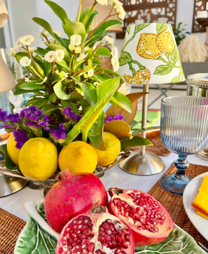 Mediterranean styling of The Lemon fruit shade for a cordless lamp on a table with fresh lemons and pomegranates.
