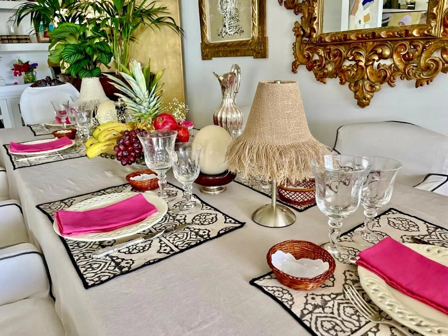 Boutique burlap fringe lampshade on a silver cordless base styled with fresh tropical fruit and crystal glassware on an elegant dining table.