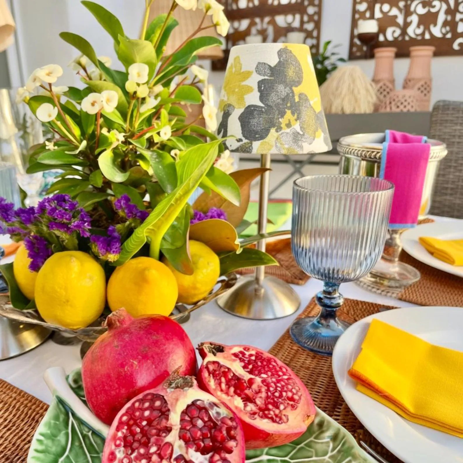 Handcrafted Ochre abstract shade on a gold cordless lamp base styled with fresh fruit and blue glassware.