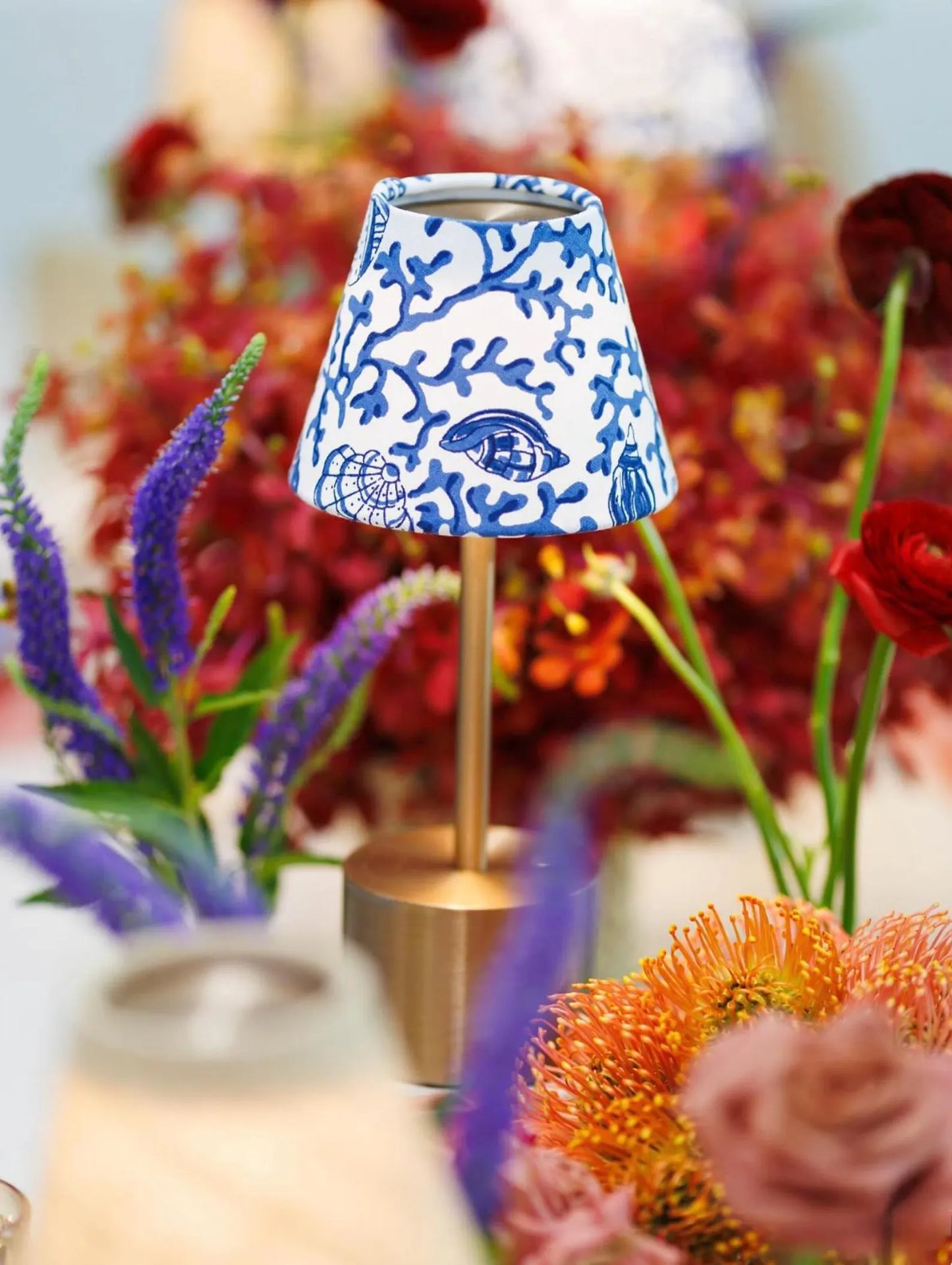 Blue Shells lamp shade styled on a gold cordless lamp, interchangeable shade for indoor and outdoor use