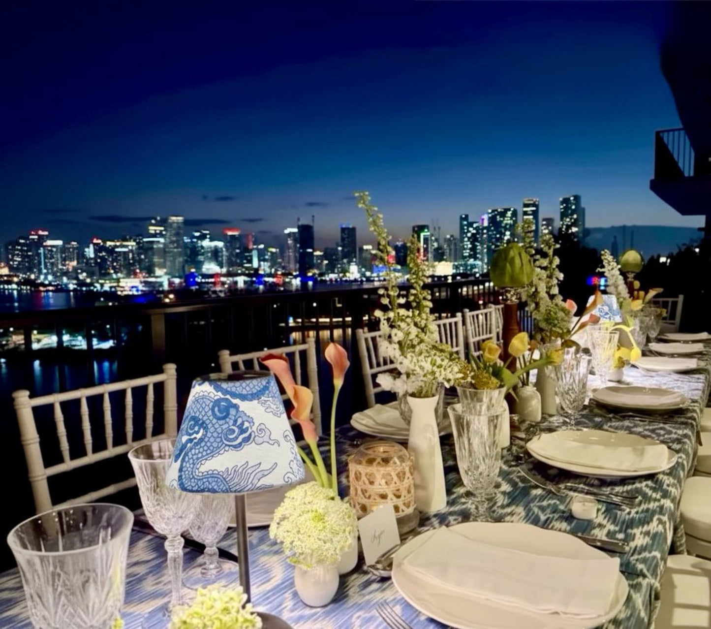 Luxury blue dragon linen shade for cordless lamps providing fire-safe ambient light for an elegant rooftop dinner with city skyline views.