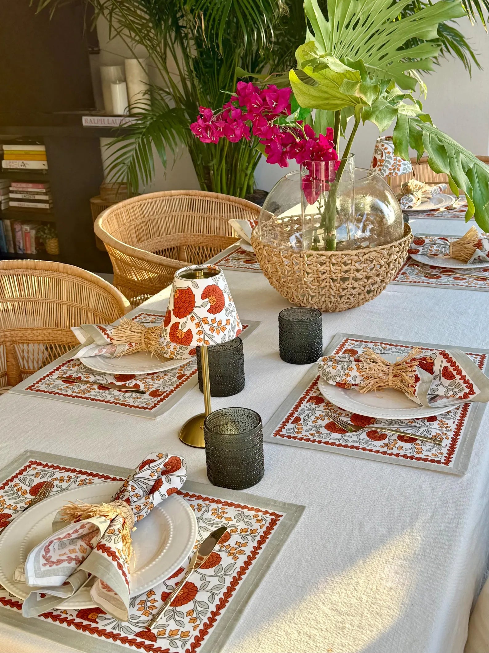Table setting featuring Marigold floral lamp shades on a cordless table lamp, rattan chairs, and a tropical centerpiece, styled for a bright and cheerful dining look
