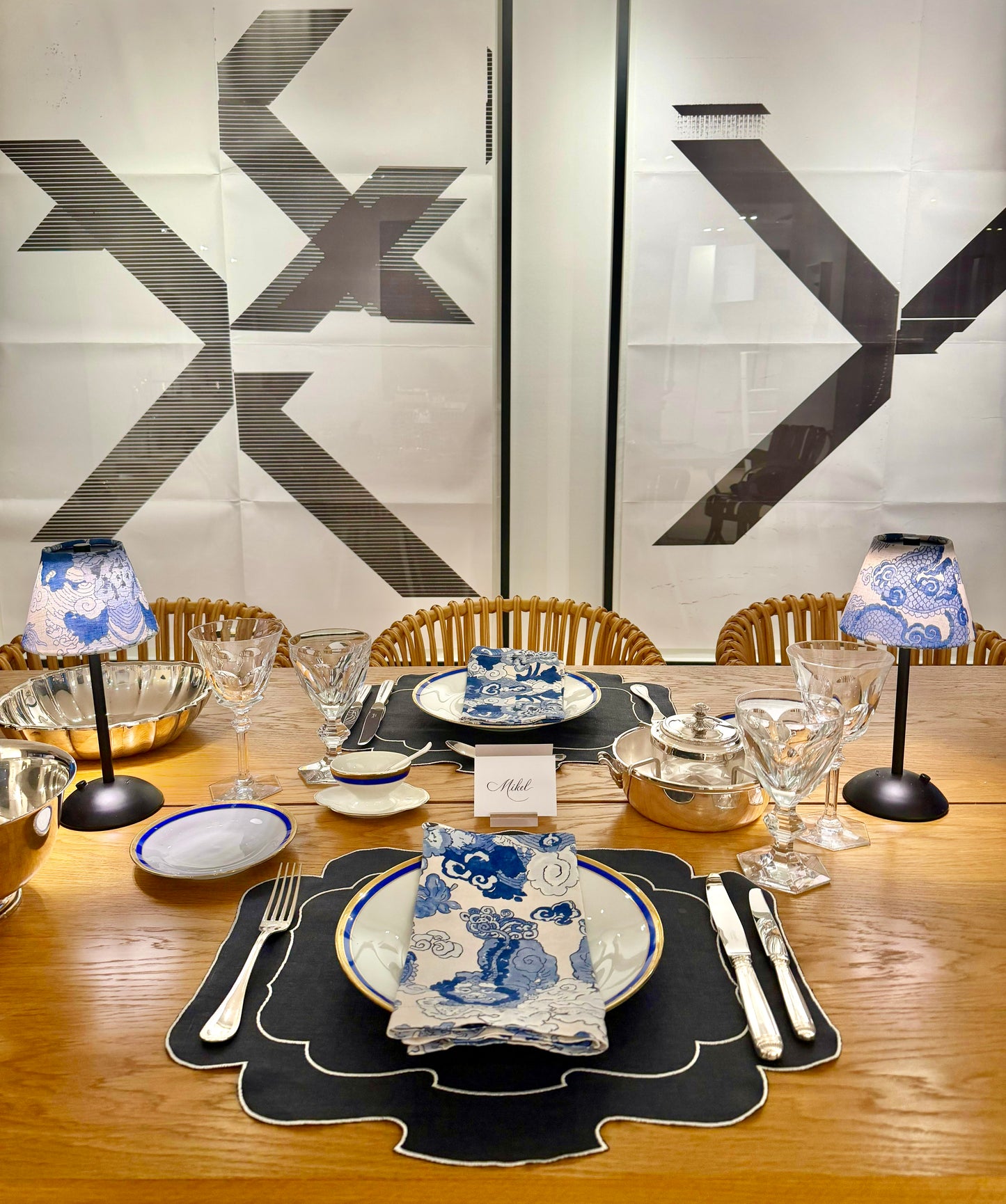 Designer wooden dining table styled with luxury blue and white china and two interchangeable Schumacher blue dragon cordless lamp shades