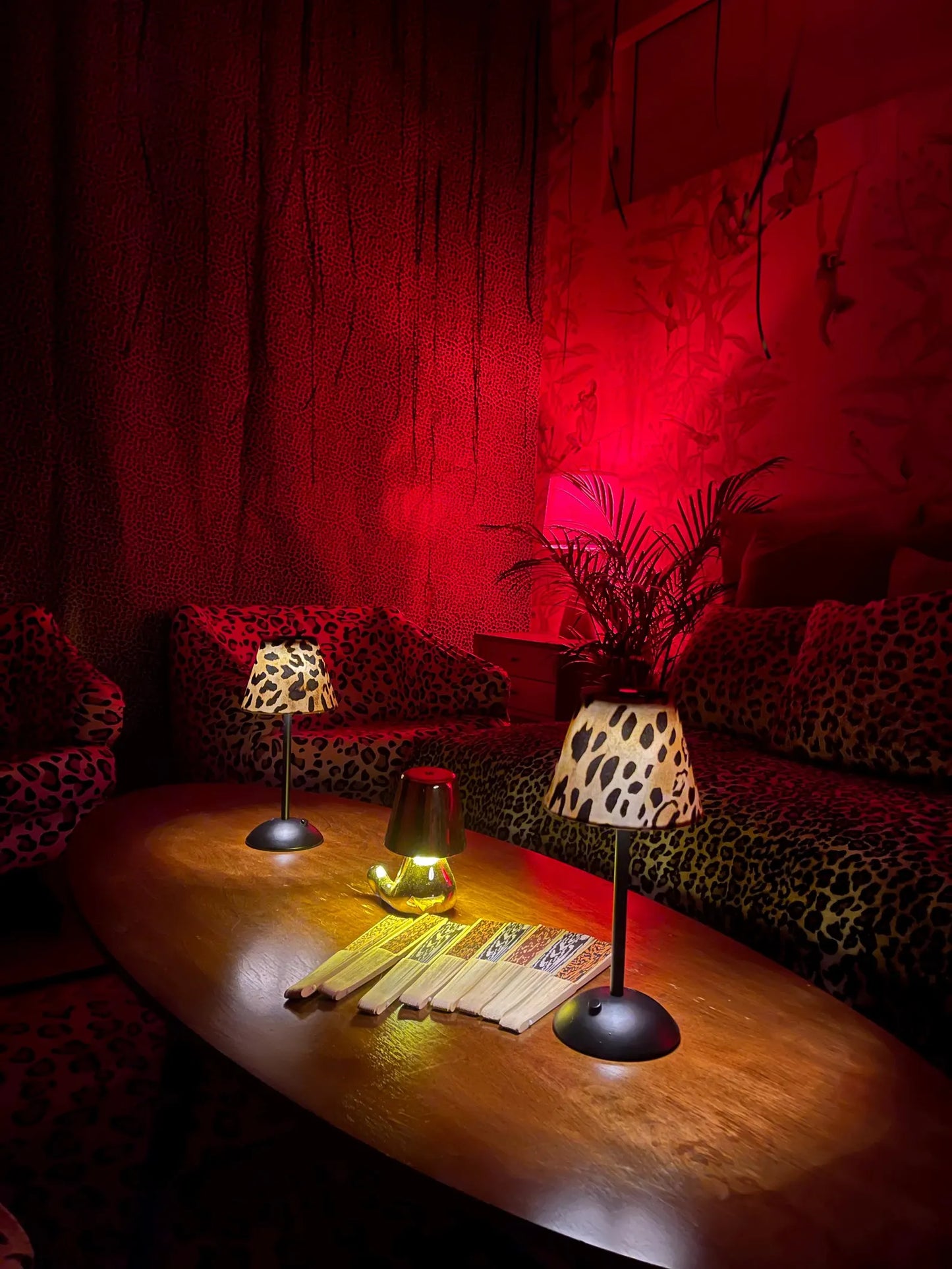 Two lit leopard print lamp shades on cordless lamps providing ambient light for an elegant dinner party tablescape.